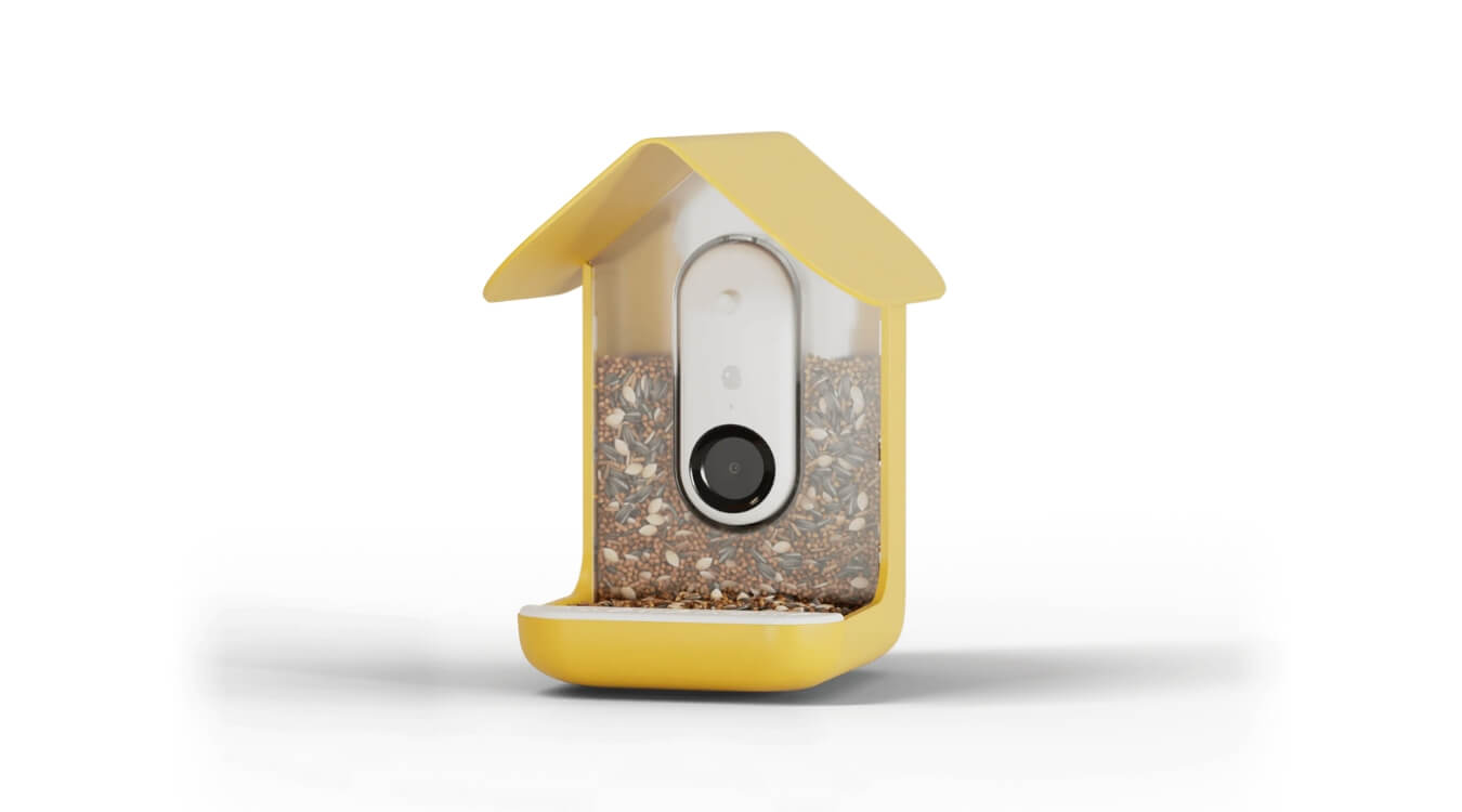 the bird buddy smart bird feeder in yellow with a built-in camera and filled with bird seeds